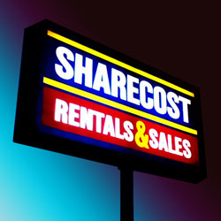 A photo of the Sharecost sign at night.